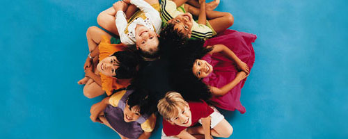 multi-ethnic children sitting in a circle looking up